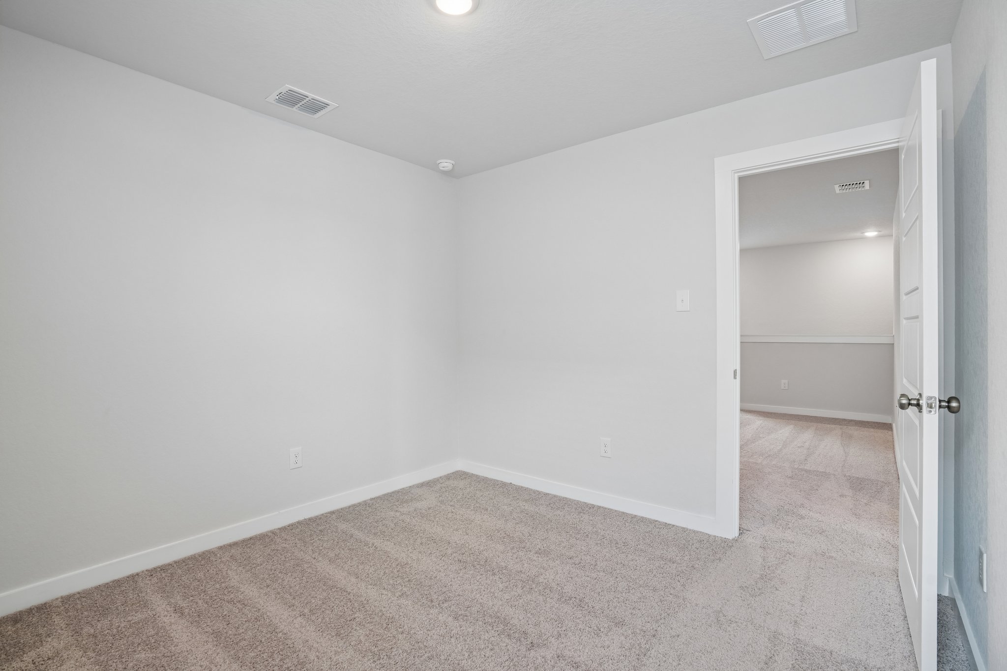 A room with a carpet and a door.