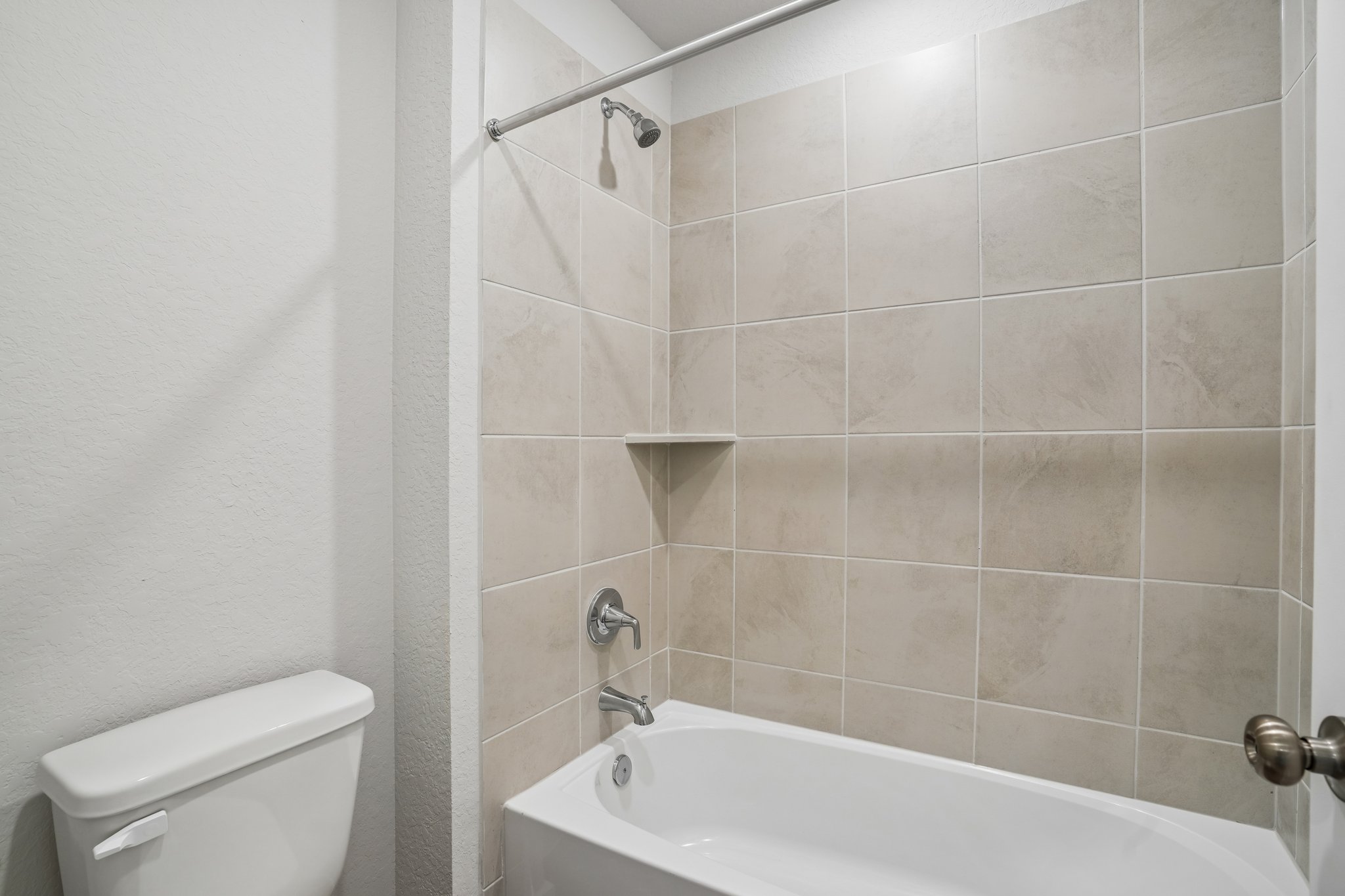 A bathroom with a bathtub and toilet.