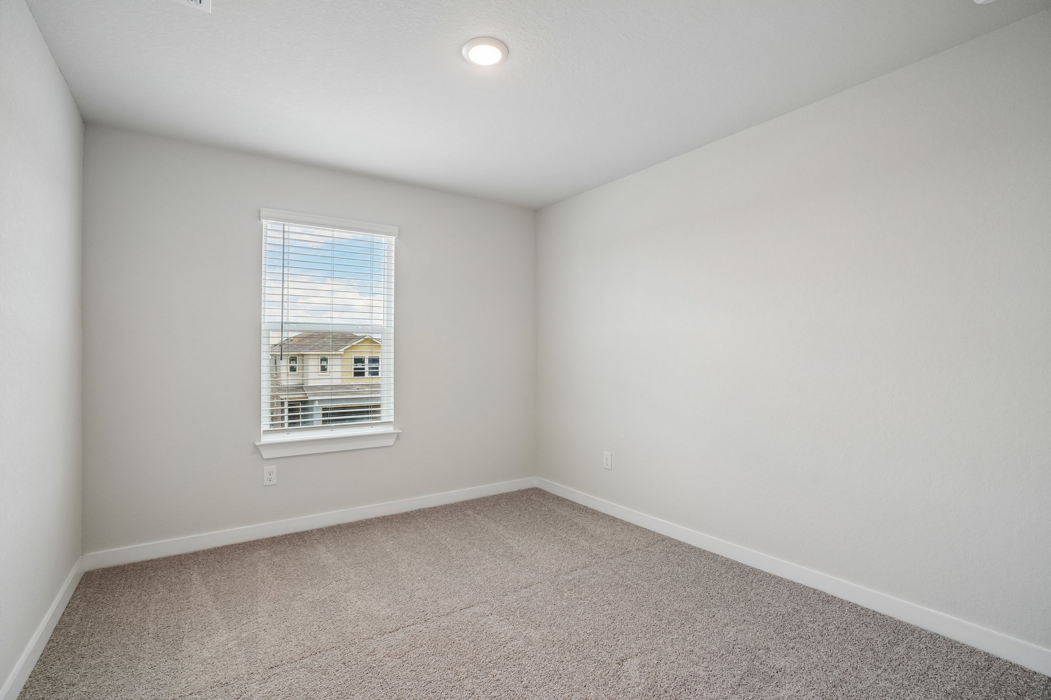 A room with a window and a carpet.