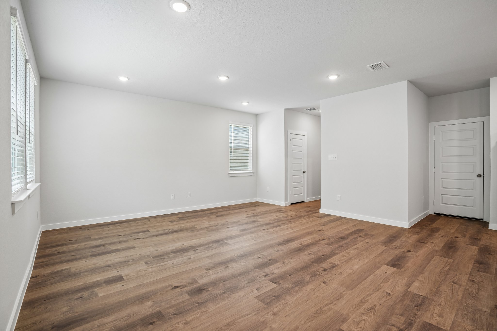 A room with white walls and wood floors.