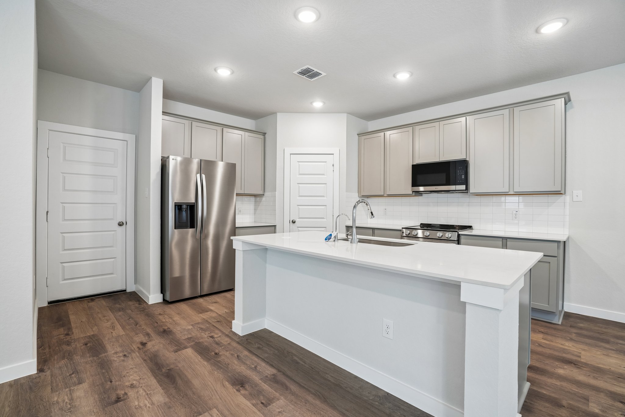 A kitchen with white cabinets.