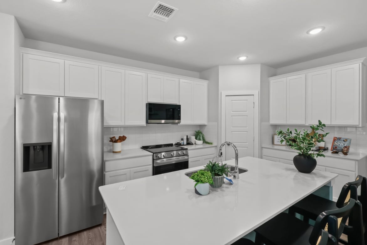 A kitchen with white cabinets.
