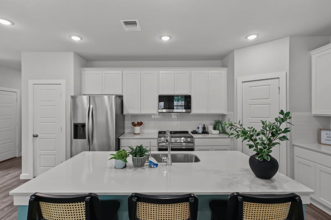 A kitchen with white cabinets.
