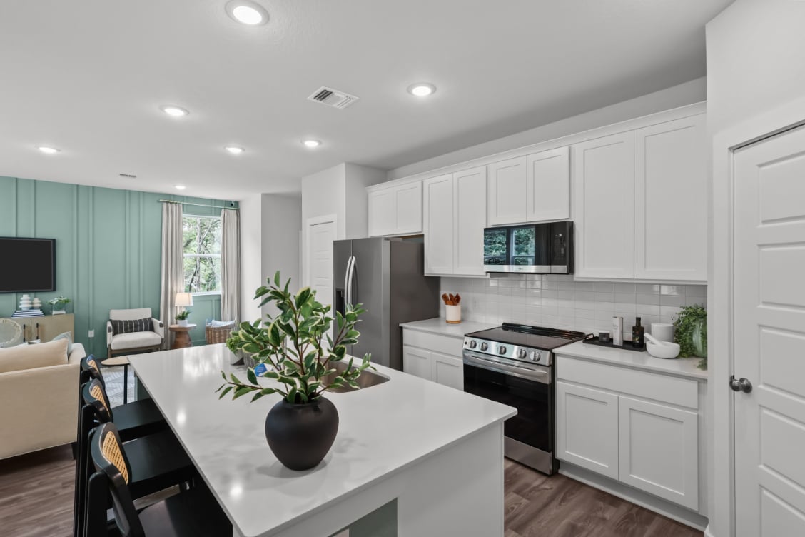 A kitchen with white cabinets.