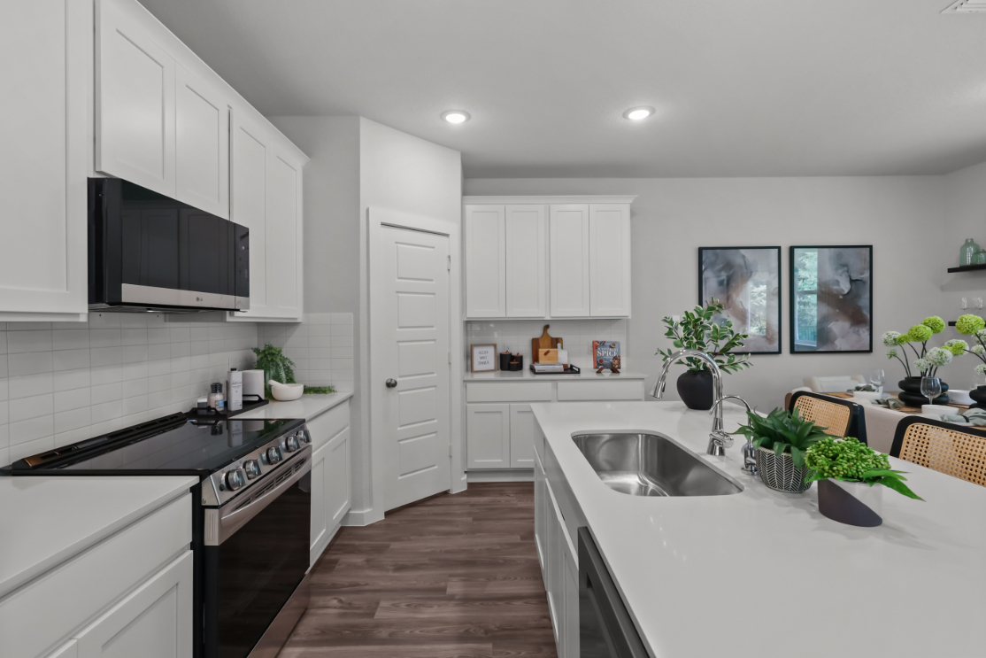 A kitchen with white cabinets.