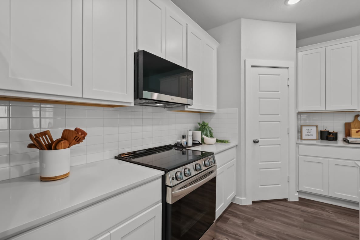 A kitchen with white cabinets.