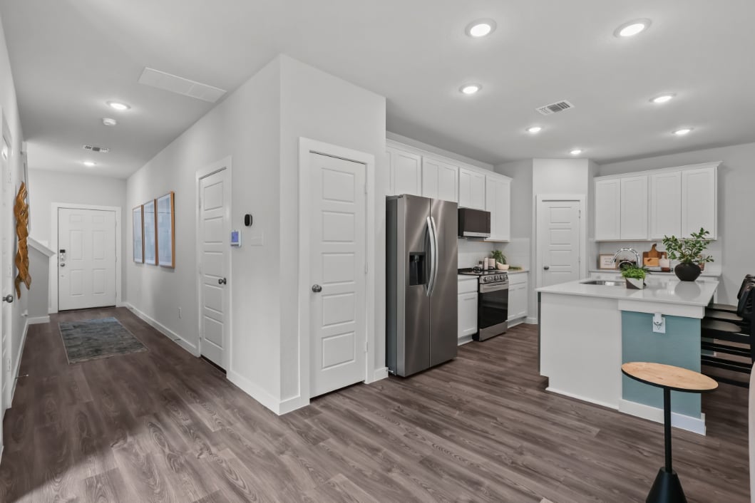 A kitchen with white cabinets.