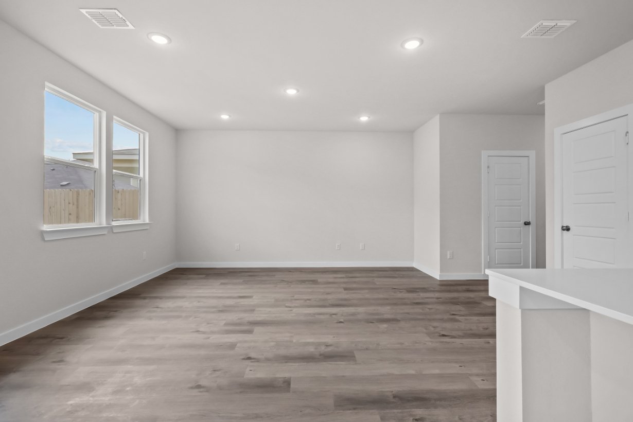 A room with white walls and wood floors.