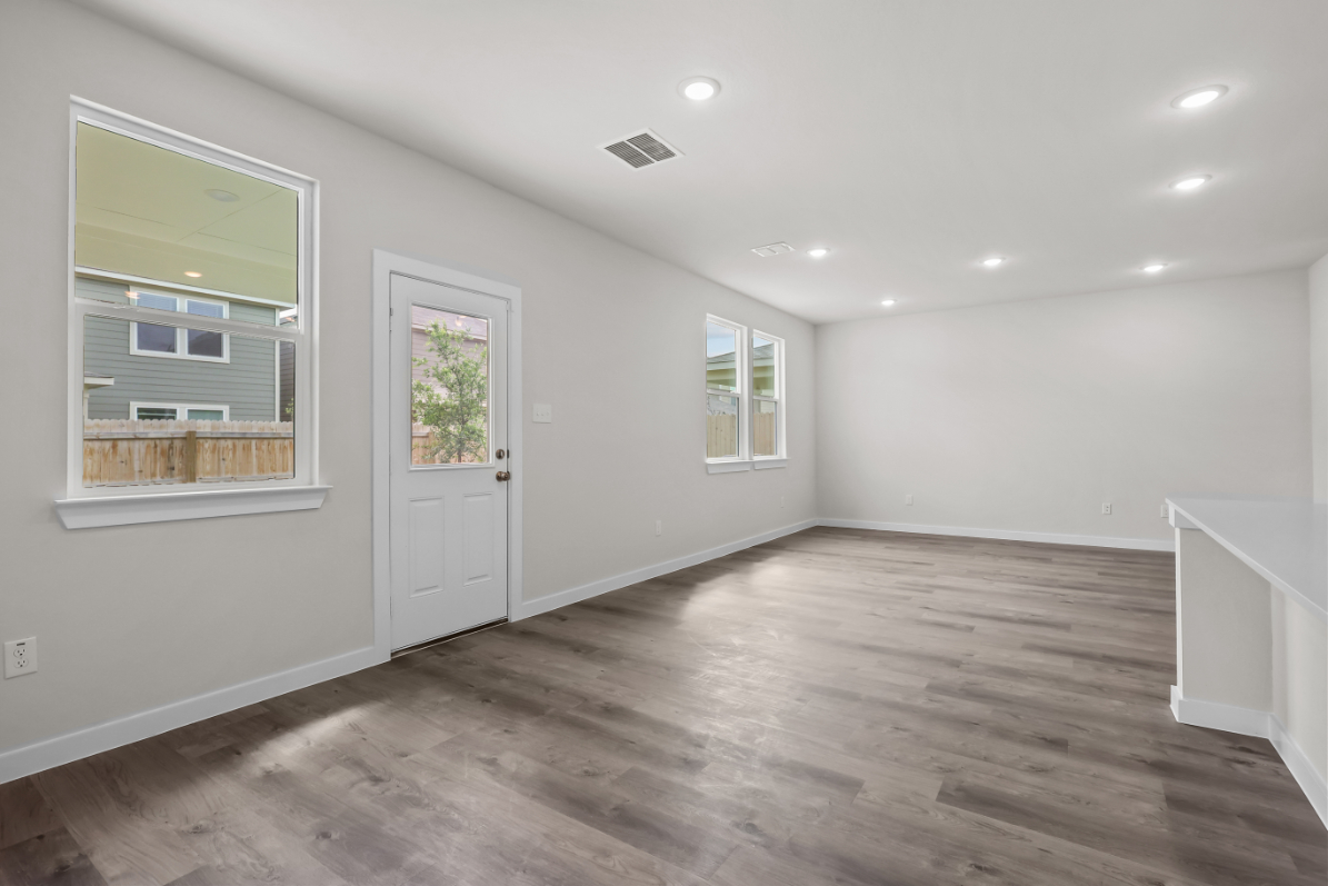 A room with white walls and wood floors.