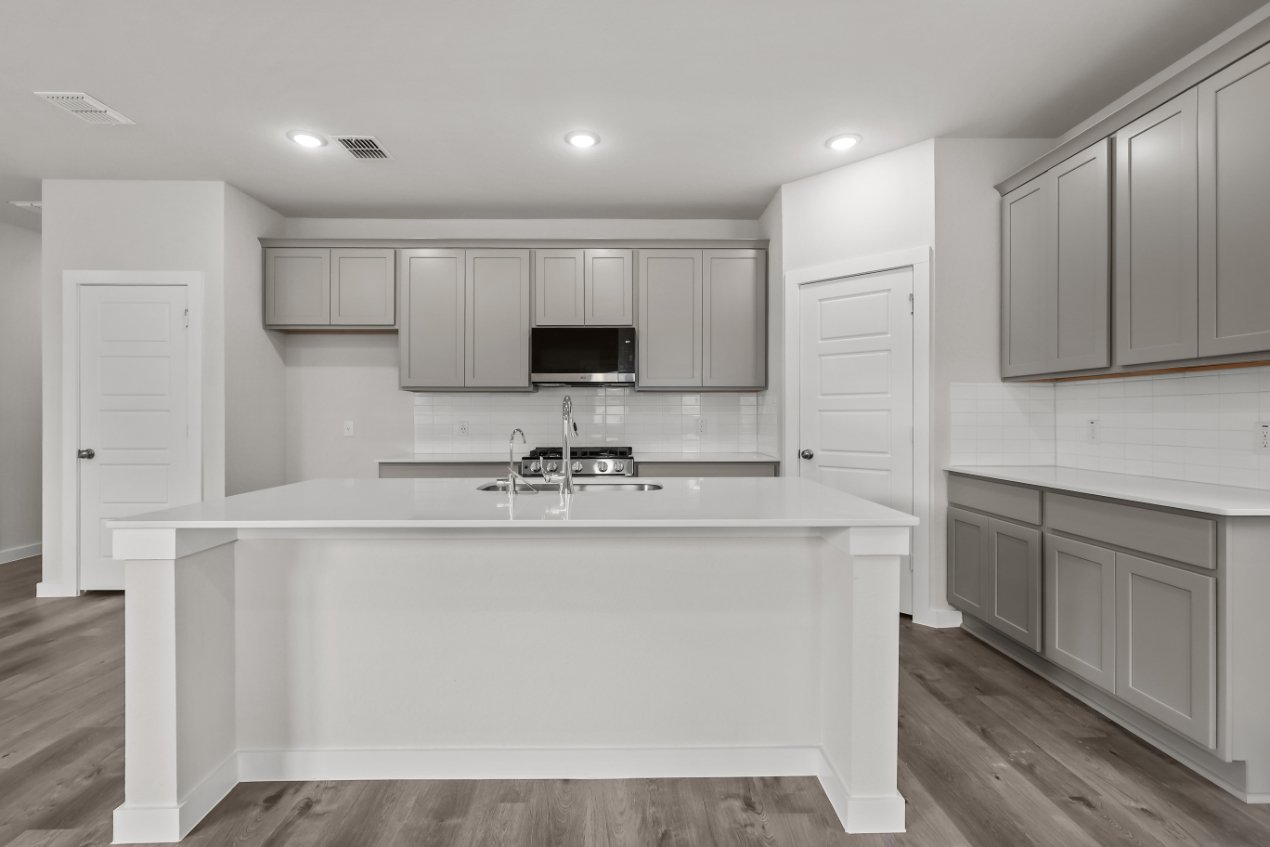 A kitchen with white cabinets.