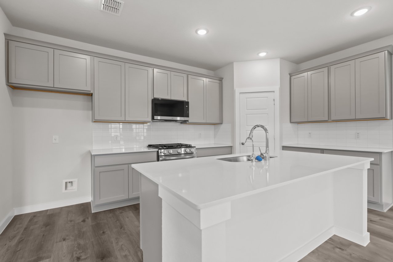 A kitchen with white cabinets.