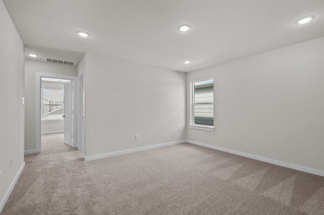 A room with a carpet and a door.