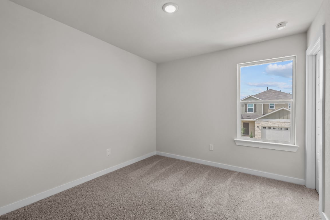 A room with a window and a carpet.