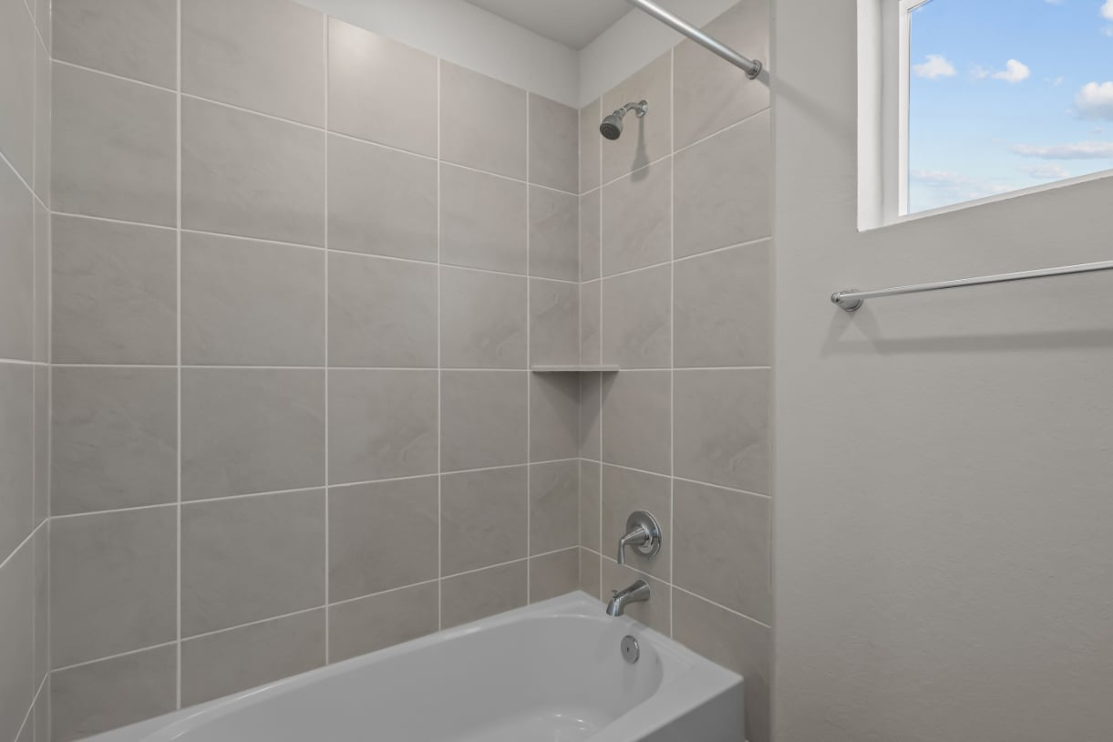 A bathroom with a bathtub and shower.