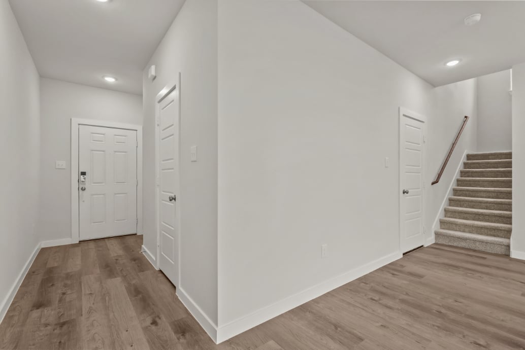A white hallway with white doors.