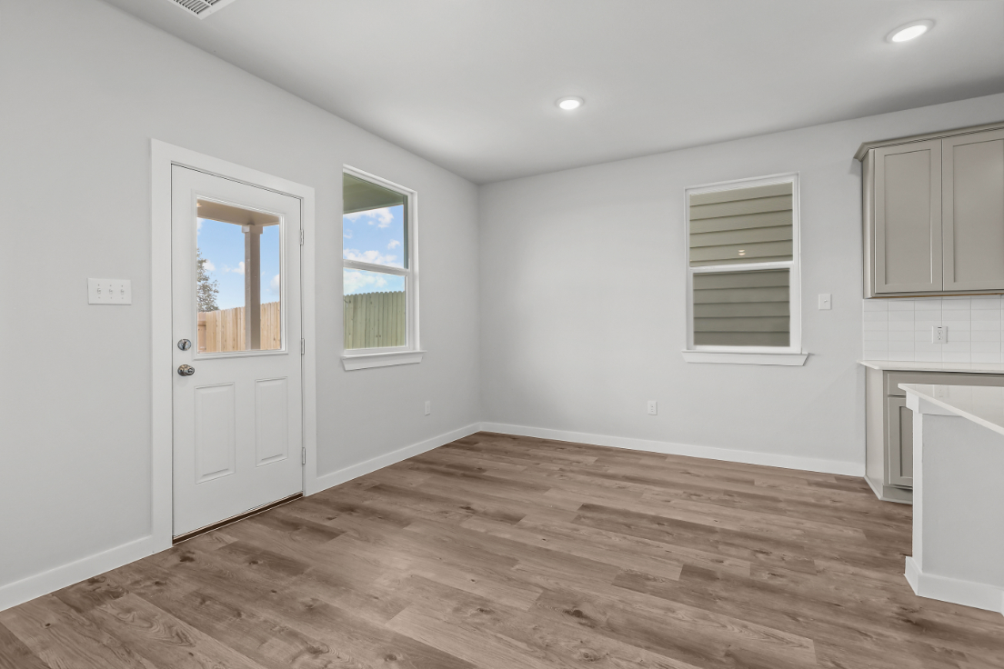 A room with white walls and a wood floor.