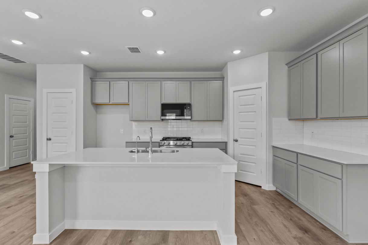 A kitchen with white cabinets.