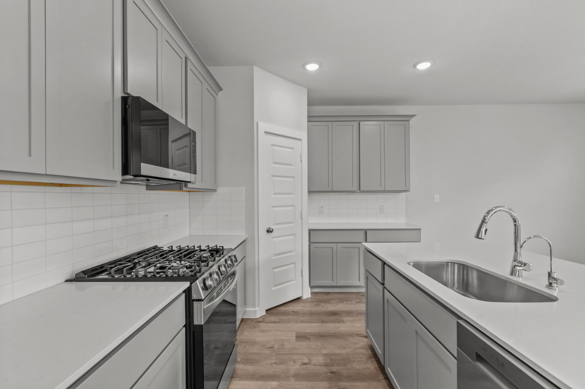 A kitchen with white cabinets.