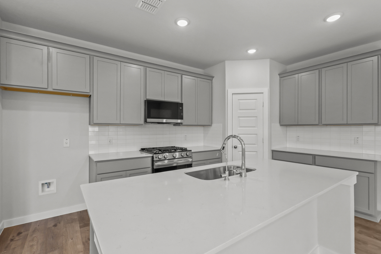 A kitchen with white cabinets.