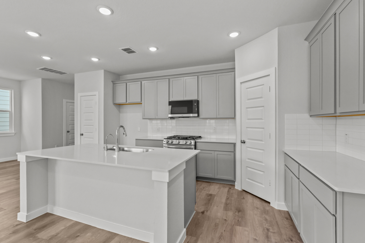 A kitchen with white cabinets.