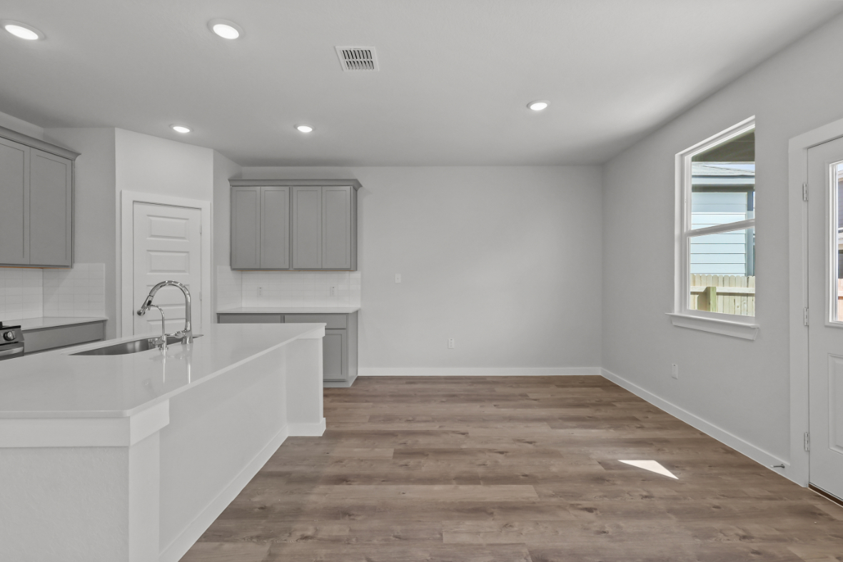 A kitchen with white cabinets.