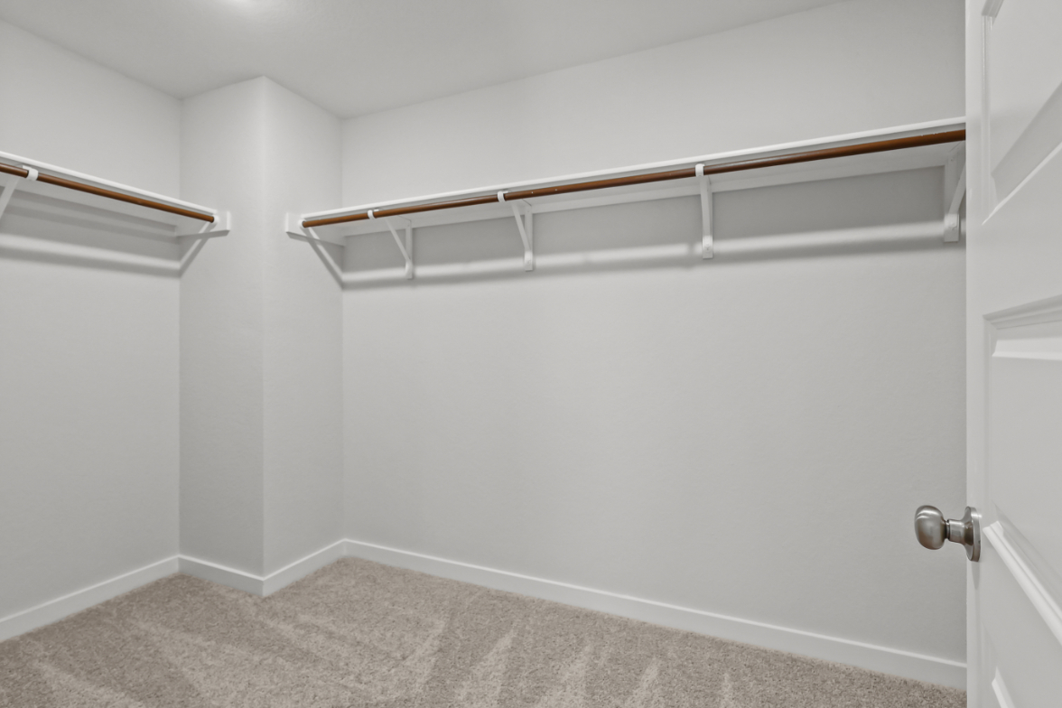 A white wall with a metal bar.