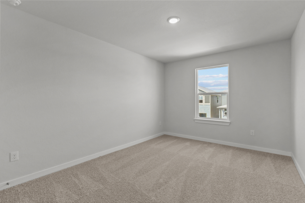 A room with a window and carpet.