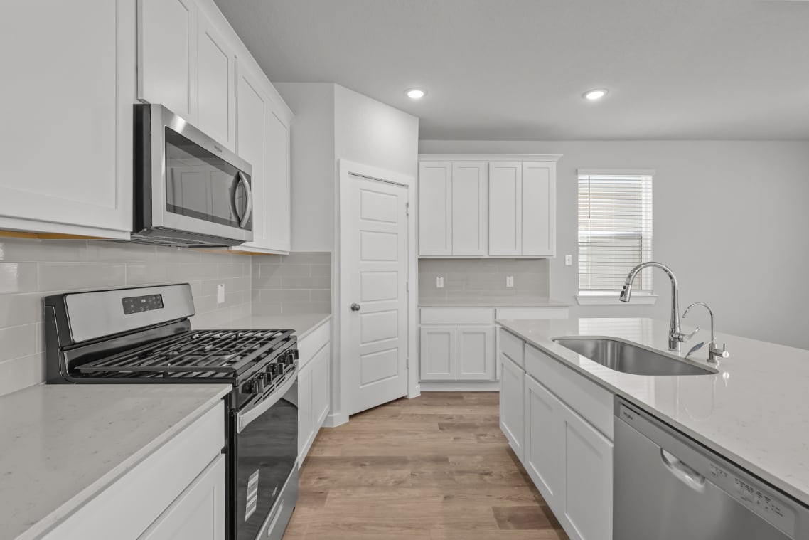 A kitchen with white cabinets.