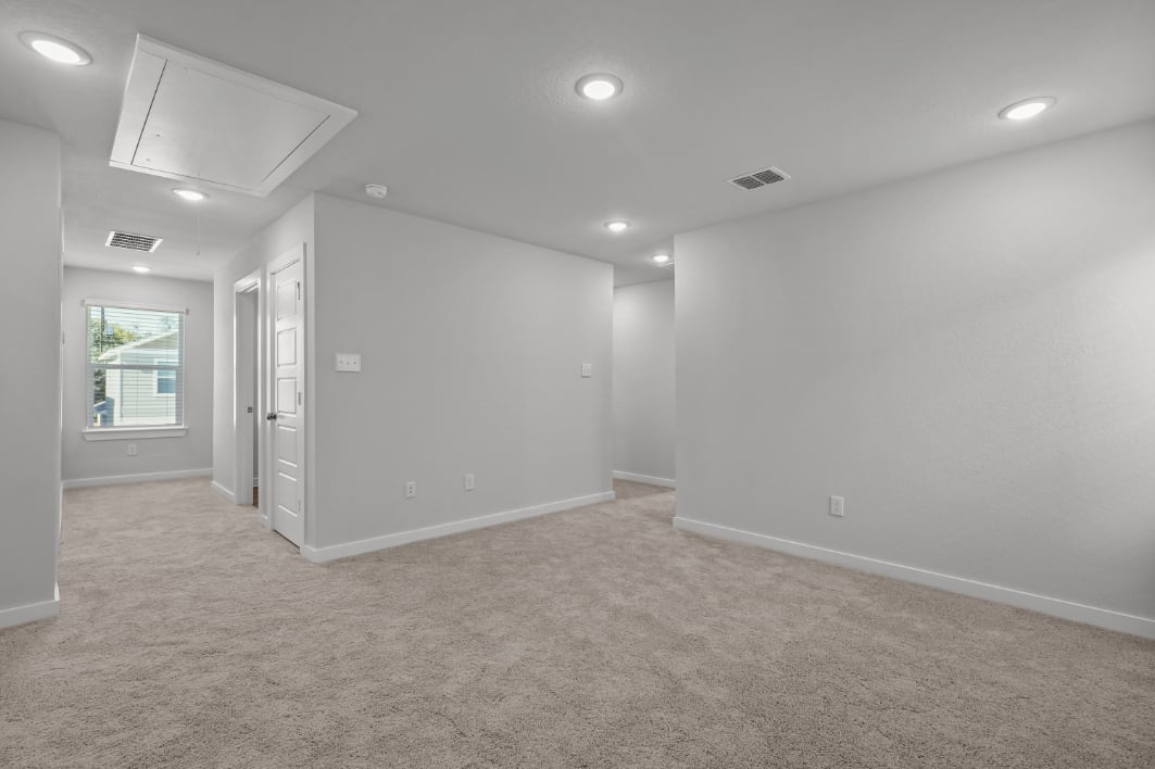 A room with a white wall and a window.