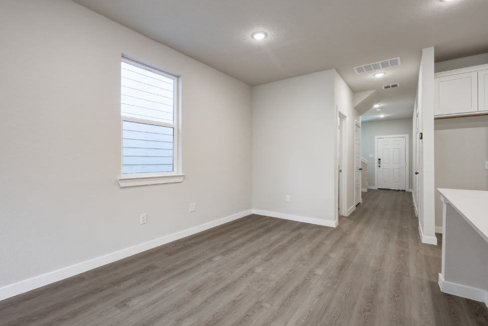 A room with white walls and wood floors.