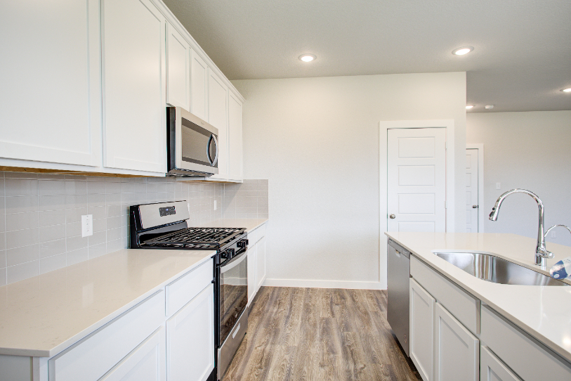 A kitchen with white cabinets.