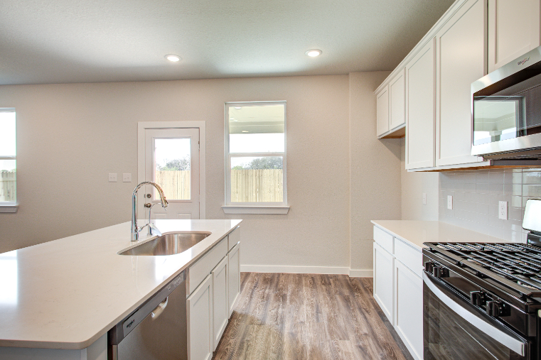 A kitchen with white cabinets.