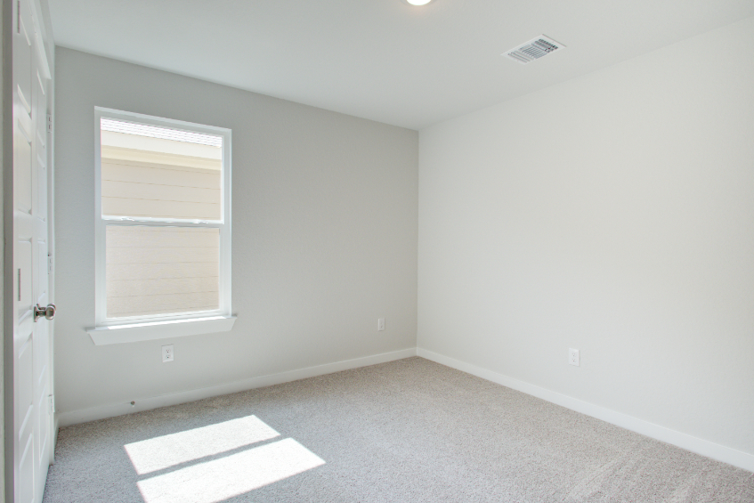A room with a rug and a window.