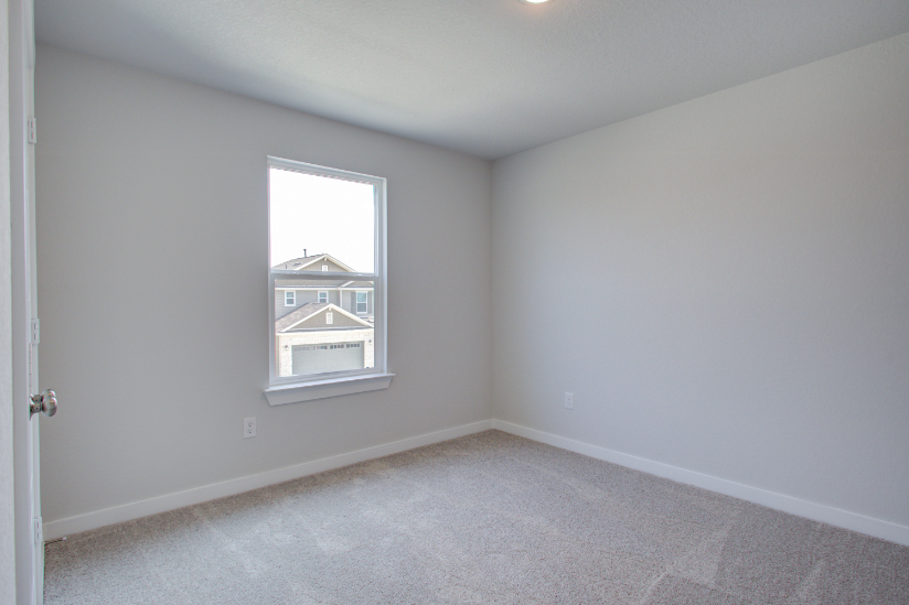 A room with a window and a carpet.