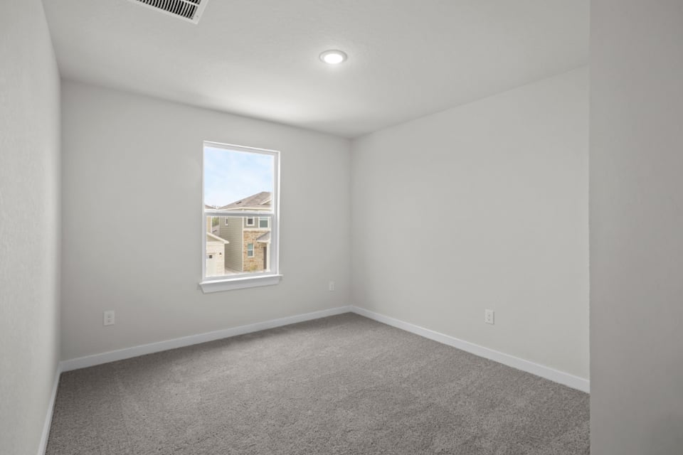 A room with a window and carpet.