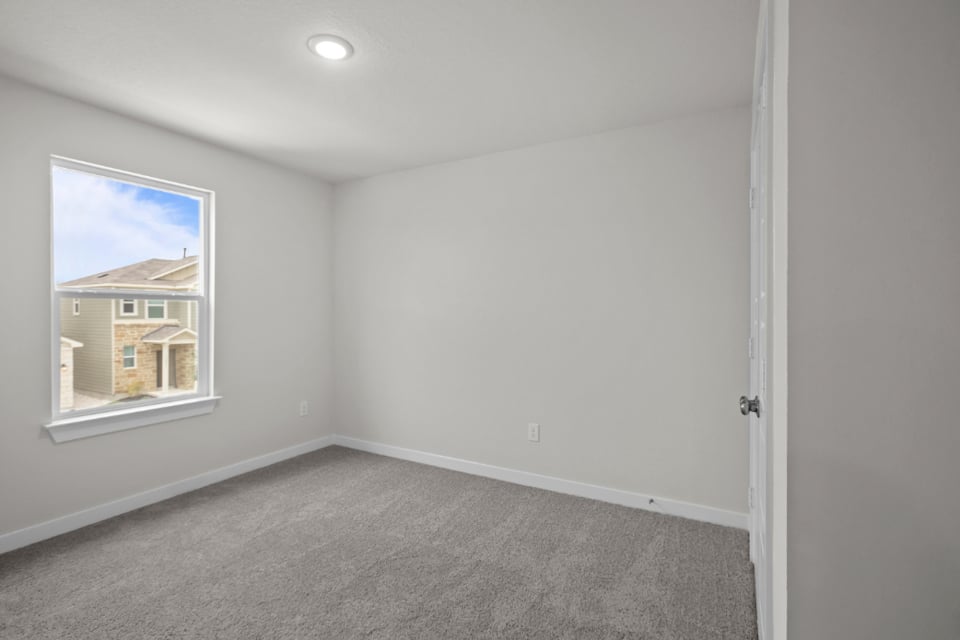 A room with a carpet and a window.