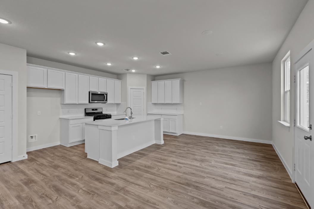 A kitchen with white cabinets.
