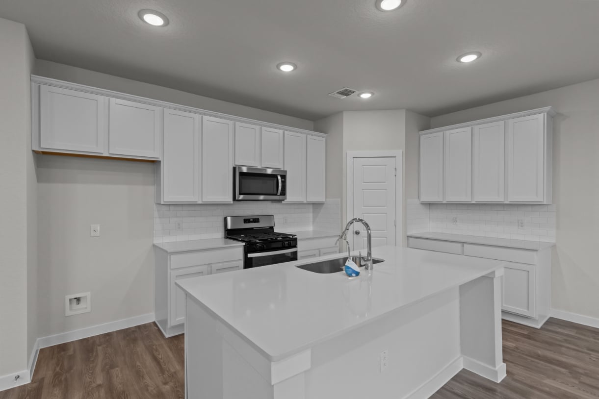 A kitchen with white cabinets.