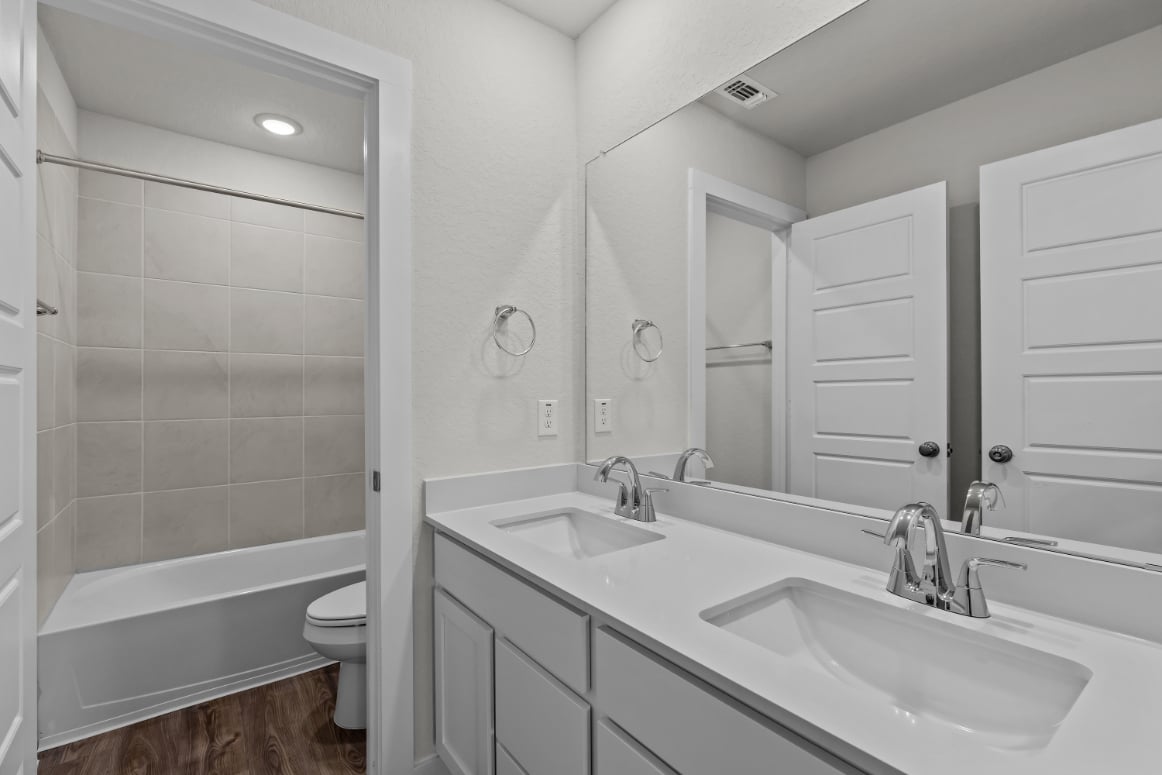 A bathroom with a tub sink and toilet.