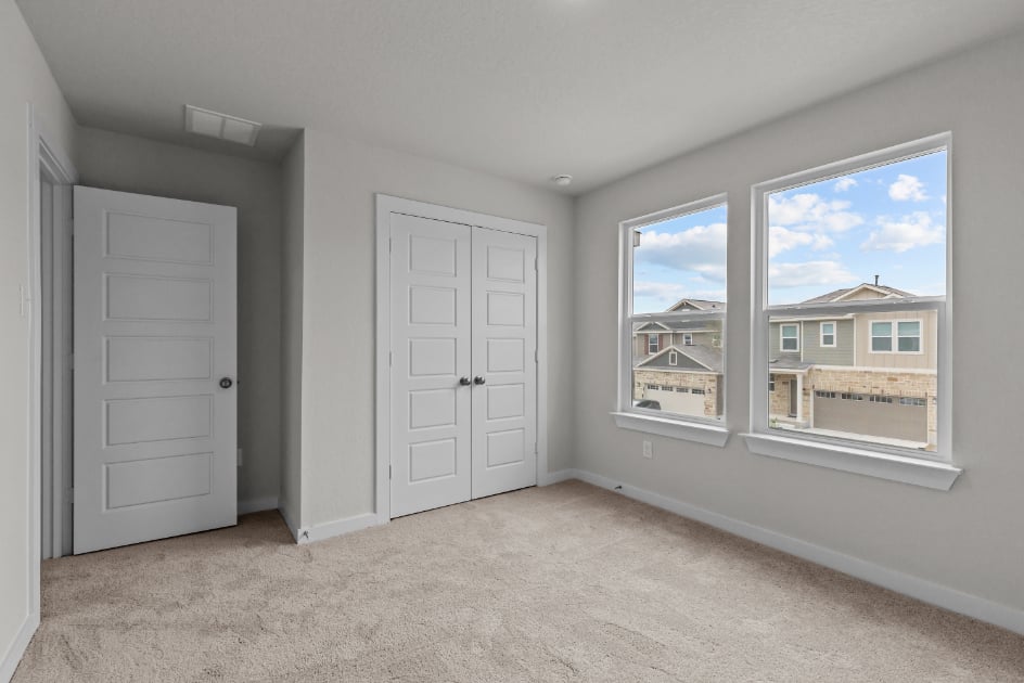 A room with white doors and a window with a view of a city.