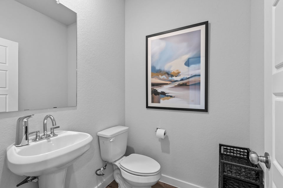 A bathroom with a picture on the wall.