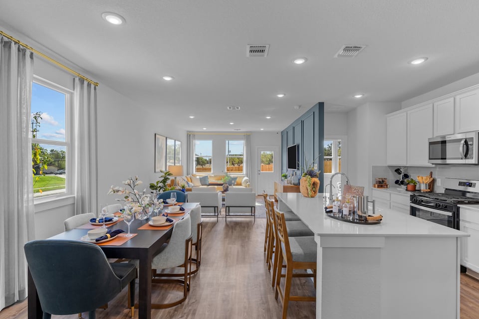 A kitchen with a dining table and chairs.