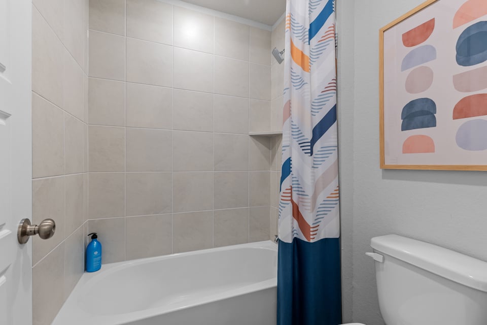 A bathroom with a blue shower curtain.