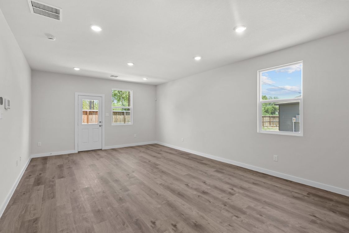 A room with a wood floor and a wood floor with a window.