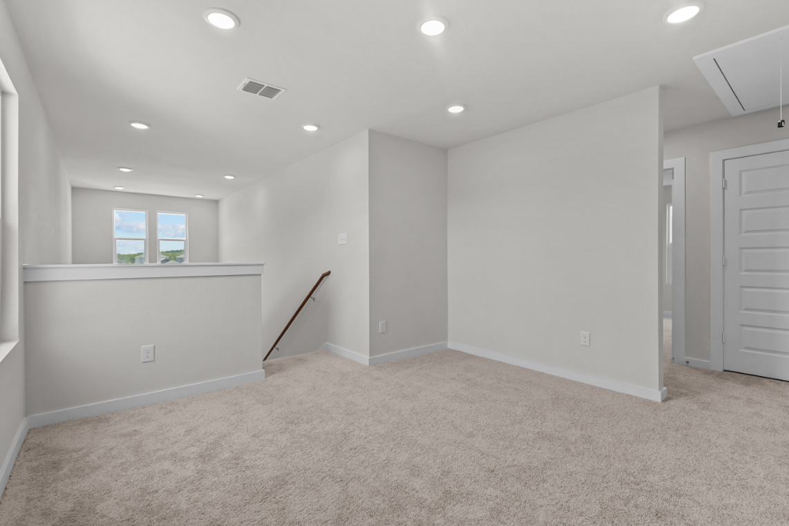 A room with a carpet and a broom in it.