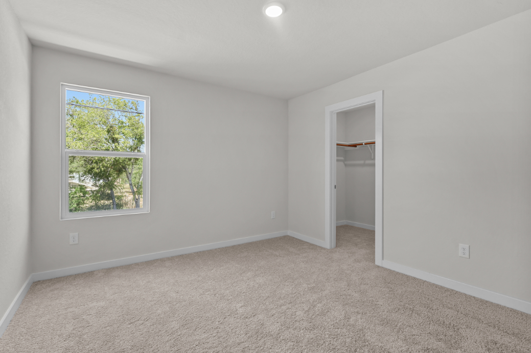 A room with a window and a shelf.