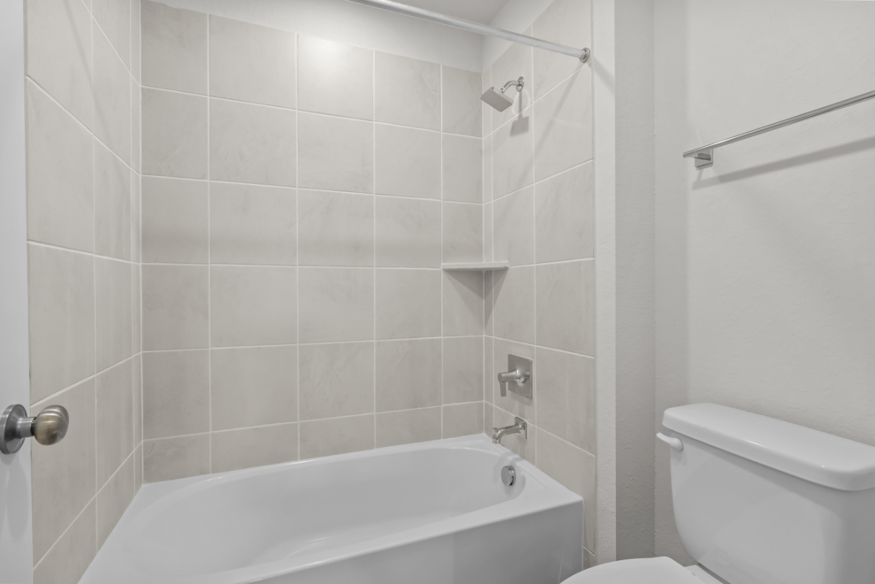 A bathroom with a bathtub and toilet.