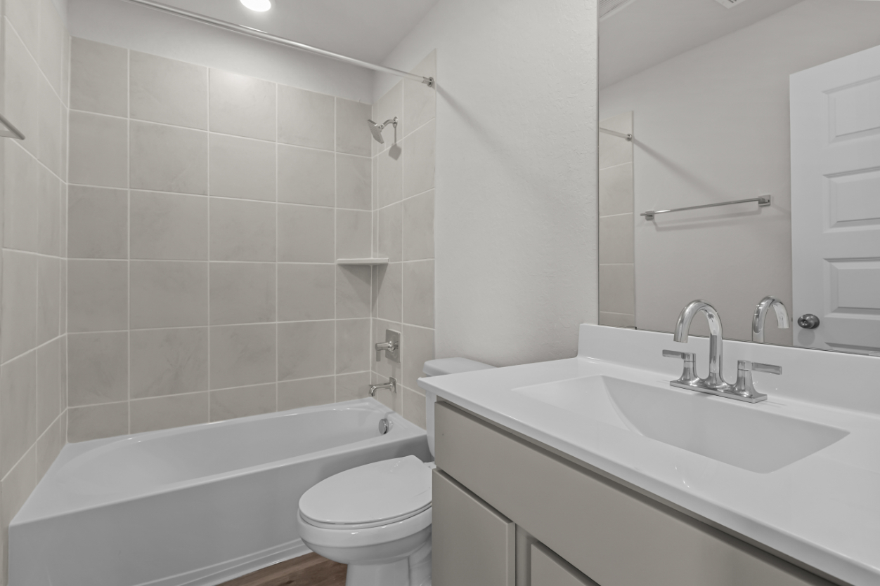 A bathroom with a sink toilet and bathtub.