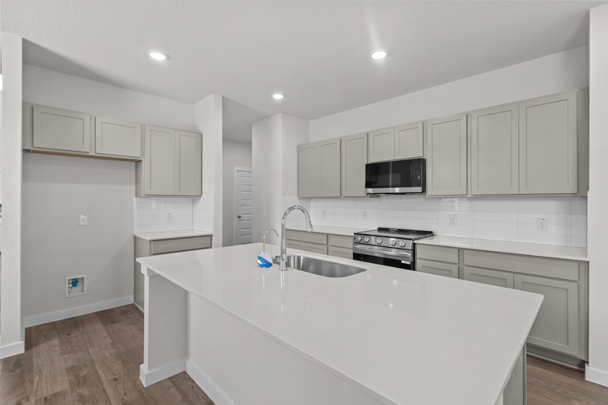 A kitchen with white cabinets.