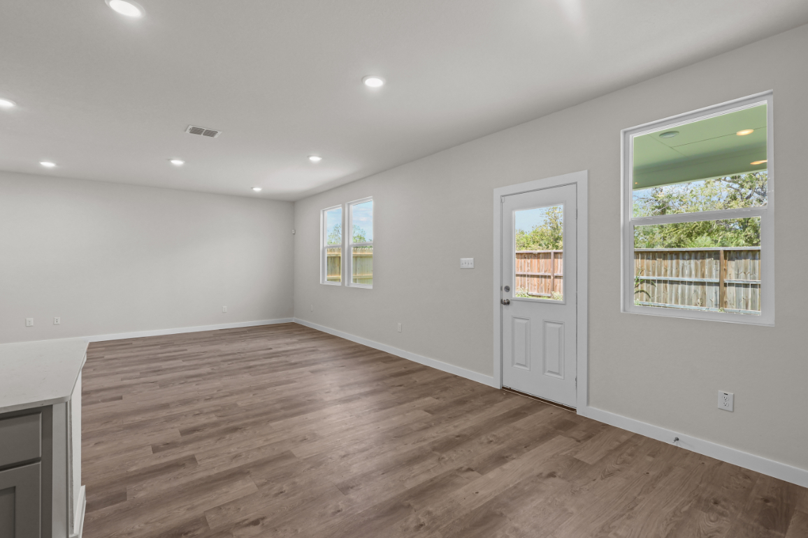 A room with a wood floor and windows.